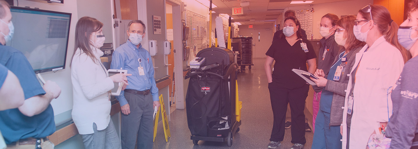 UVA Health Clinical Nurse Specialist team and front-line staff, meeting in a hallway of UVA Hospital