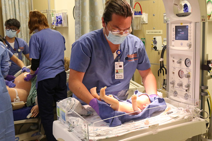 A medical student training on a mannequin baby