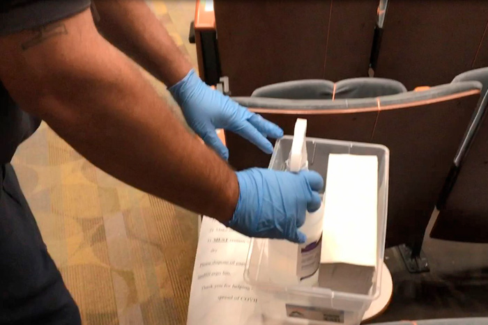 A custodian prepares classroom disinfection tool kits for customer use