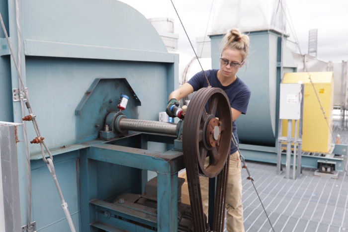 Ashley Bell works on a belt as part of the Chemistry Building's ventilation exhaust system
