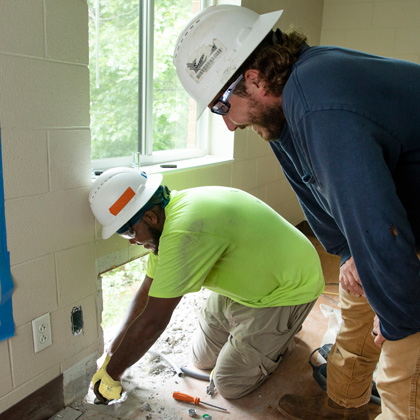 Jermey Vest installing wiring and Cody Borrelli looking over his shoulder