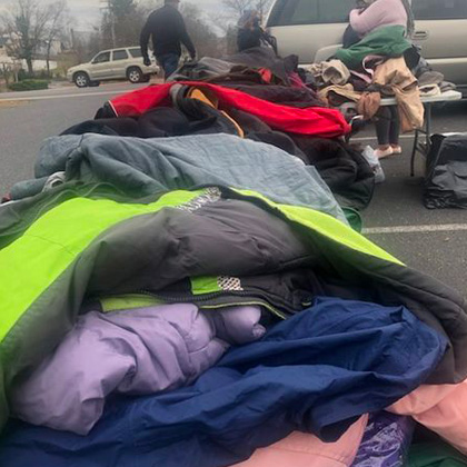 A row of tables piled high with winter clothing