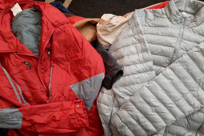 Several donated winter coats lying in layers