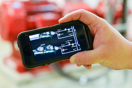 A smartphone showing digital renderings of mechanical components and readings