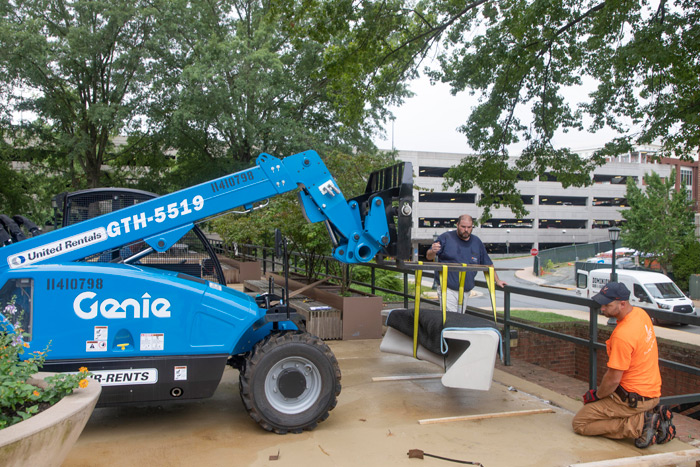 A memorial bench being installed by forklift