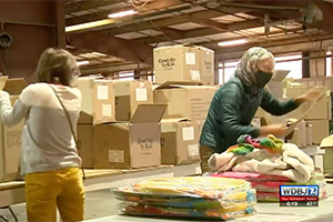 Volunteers pack boxes of donated food and toys.