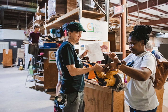 Two people examine a power tool