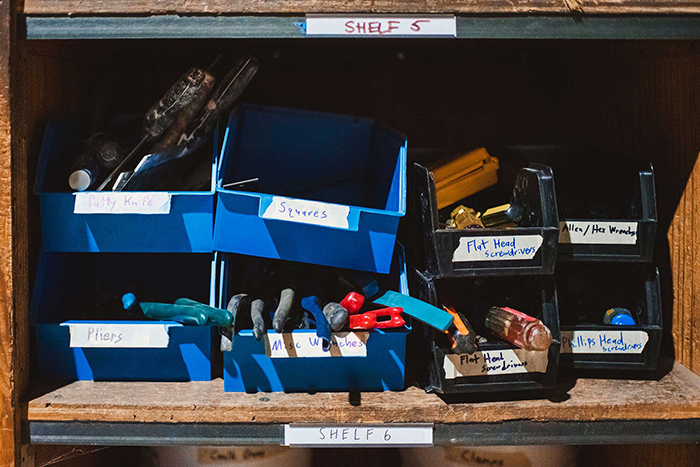 Small, labeled storage bins filled with hand tools